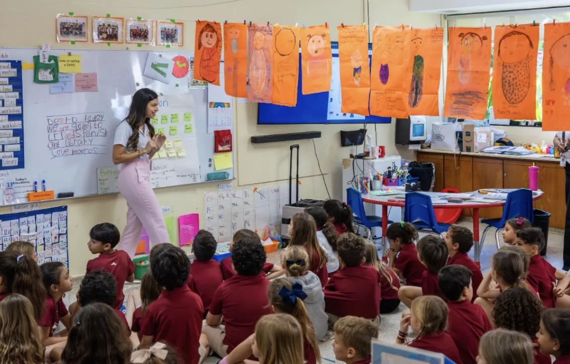 Voluntaria presentando frente a un aula del colegio Carol Morgan