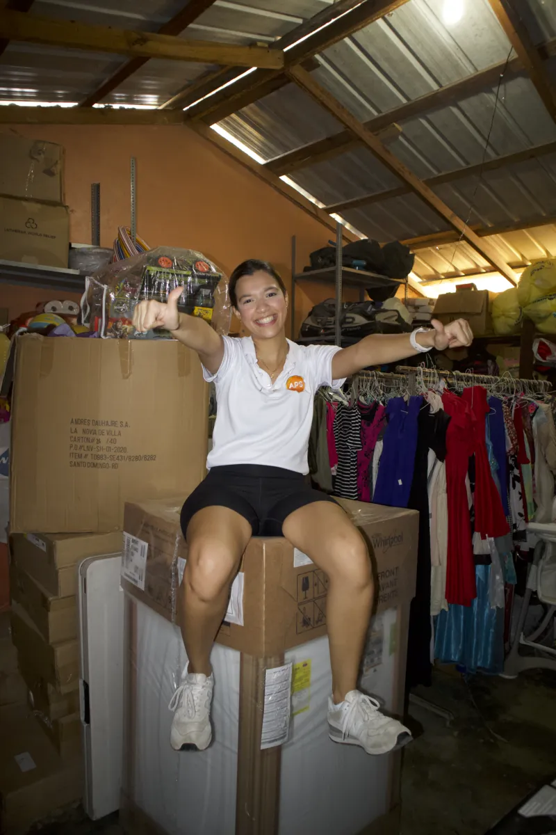 Voluntaria entre cajas y ropa donada