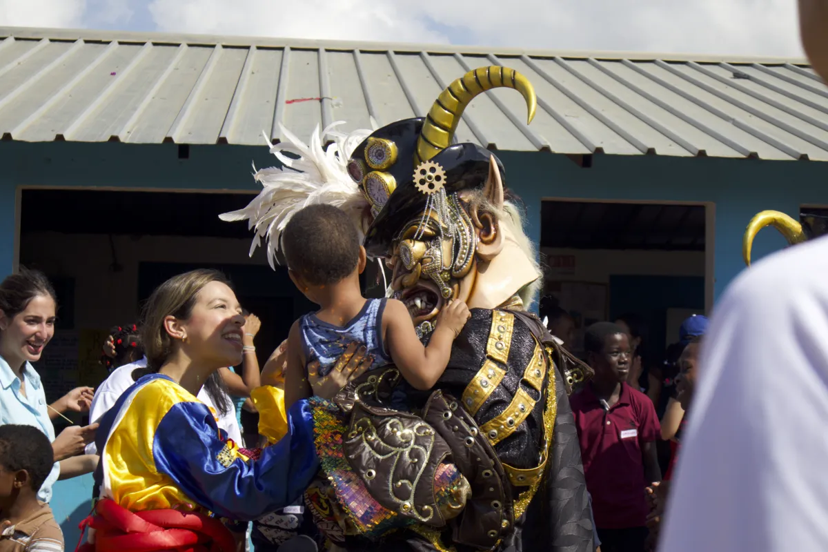 Un diablo cojuelo saluda a los niños durante el carnaval