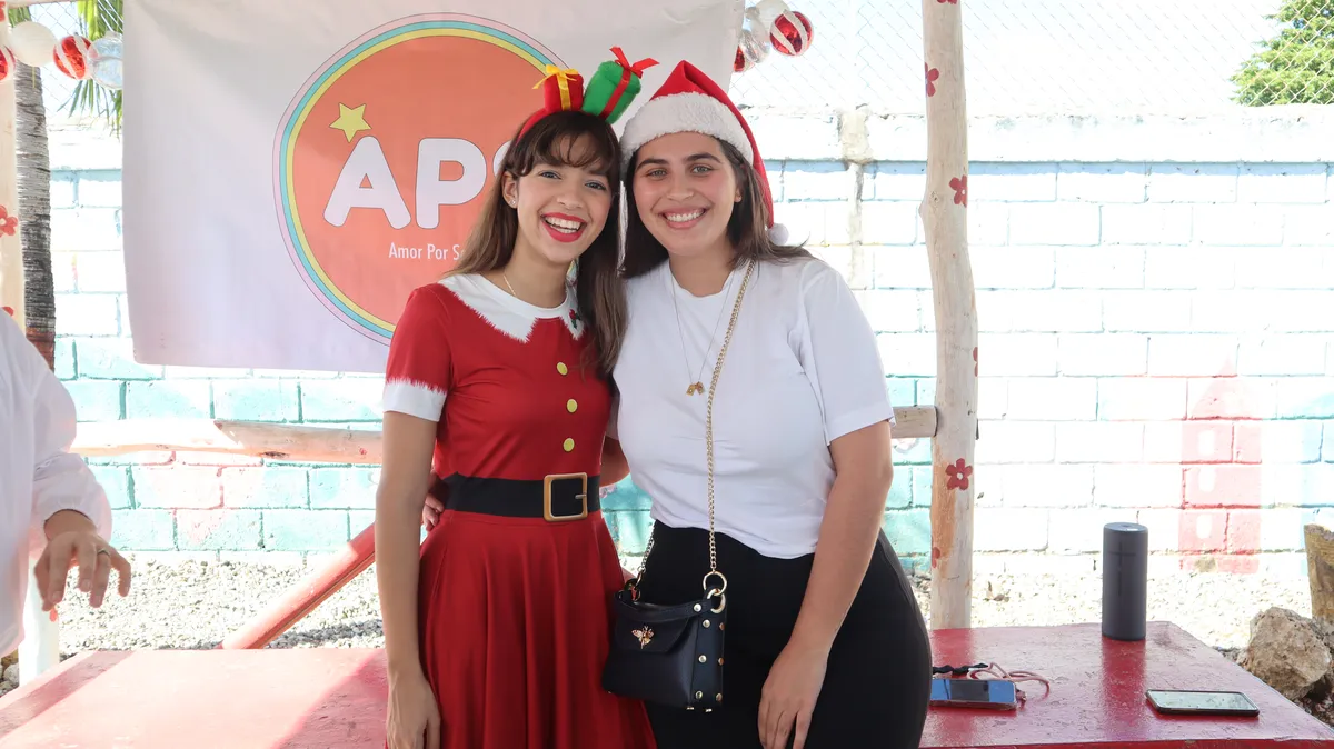 Voluntarias con el estandarte de APS en la actividad de Navidad