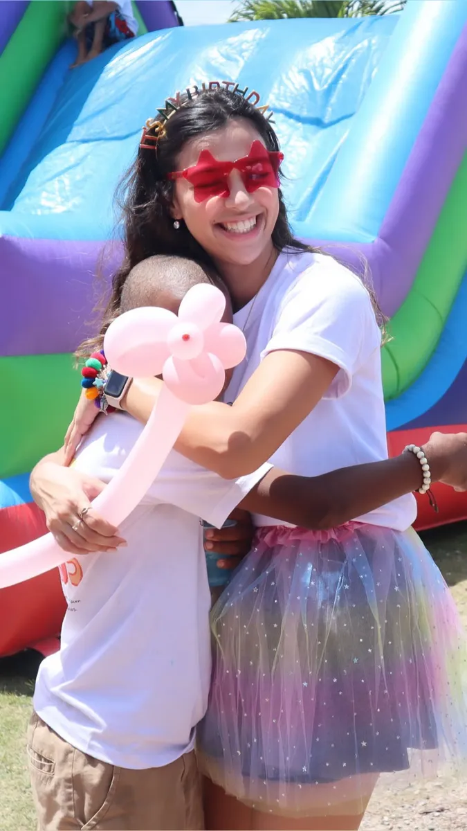 Una voluntaria de Amor Por Servir abraza a un niño durante una actividad