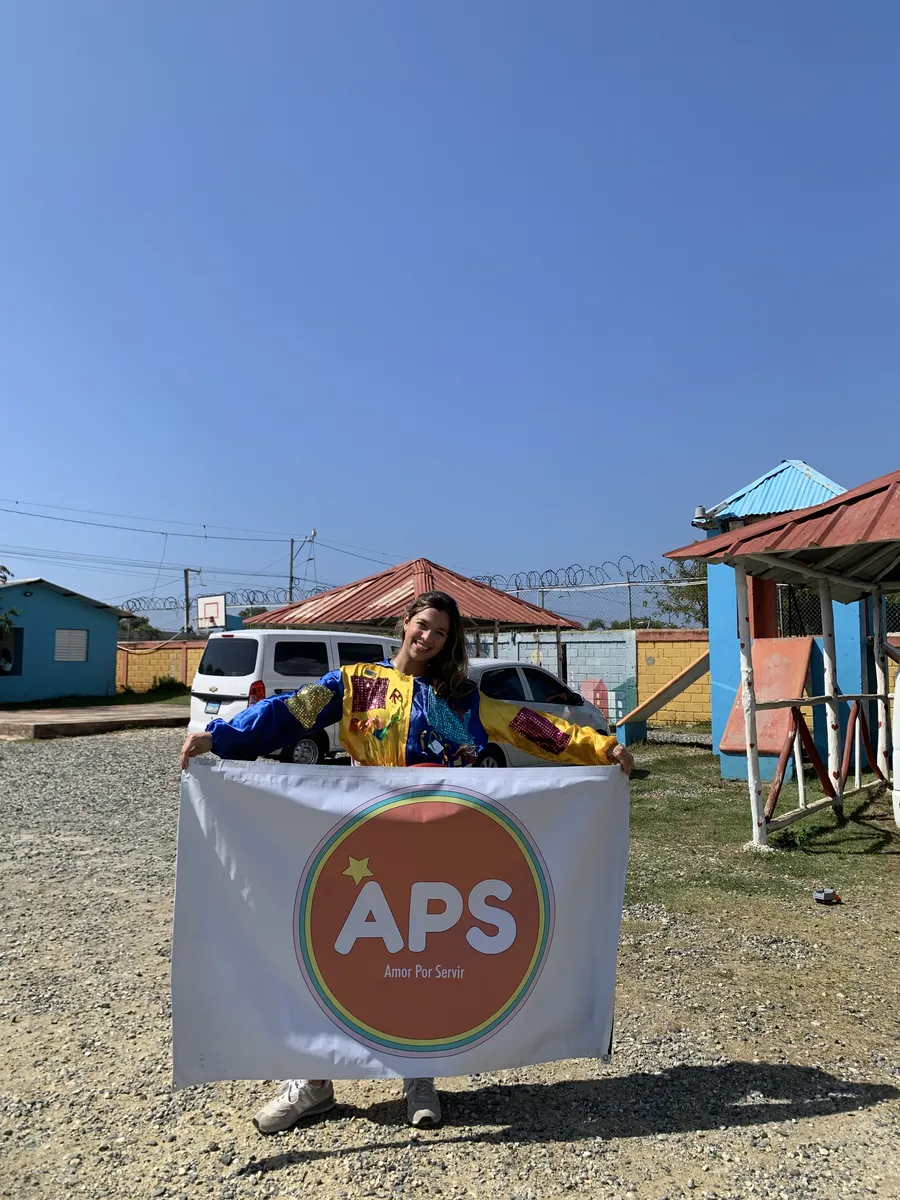 Karla Cantisano con el estandarte de Amor Por Servir en el hogar