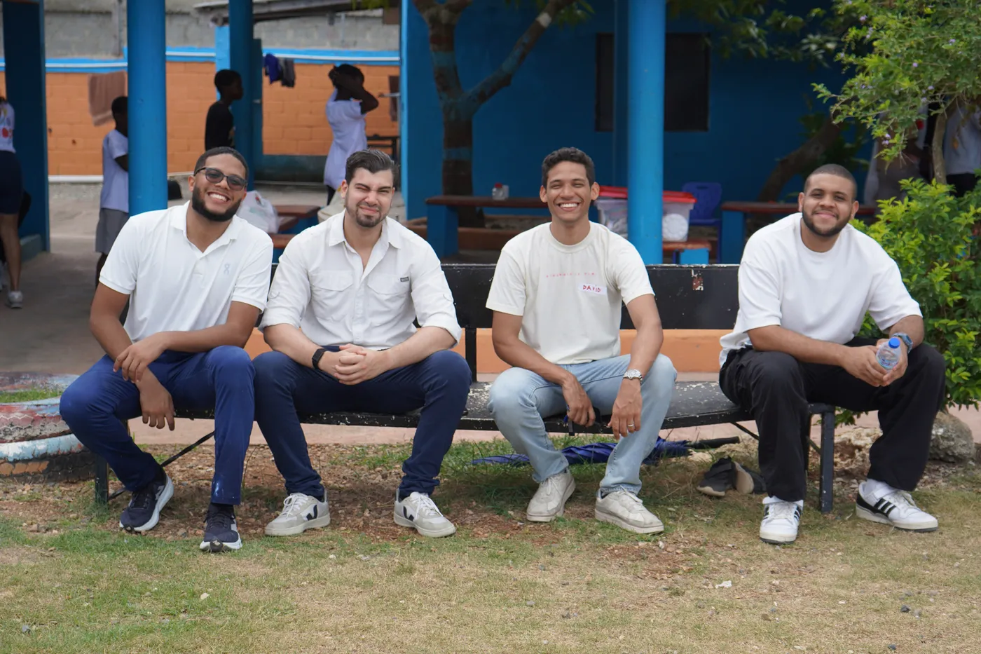 Cuatro voluntarios sentados en un banco del hogar