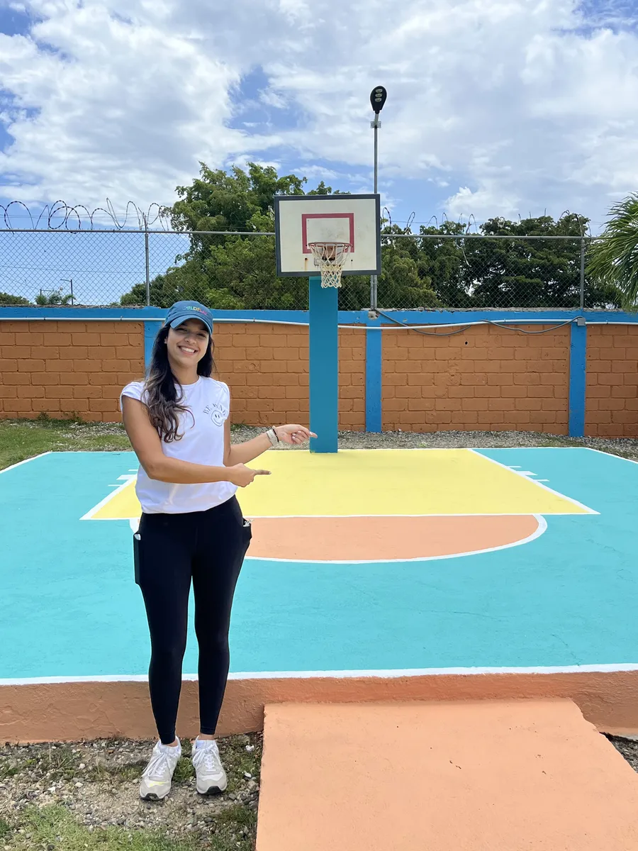 Voluntaria de pie en la cancha recién pintada