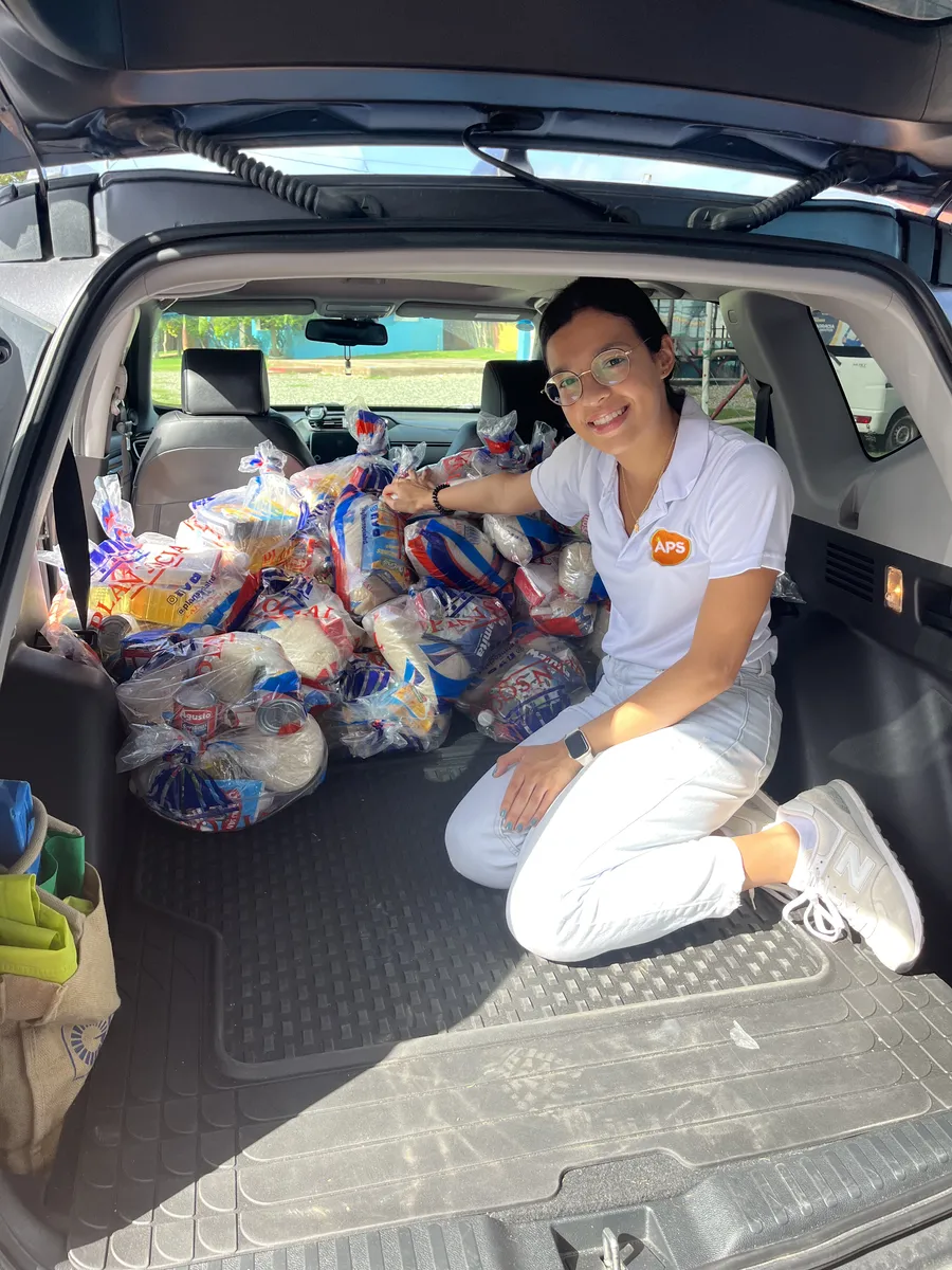 Baúl de un carro lleno de fundas con donaciones