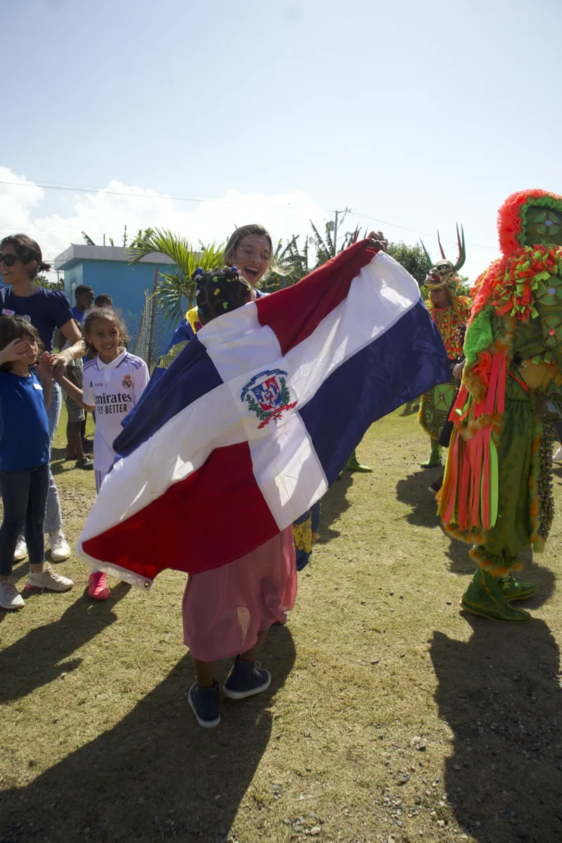 Niño ondeando la bandera dominicana en la actividad de carnaval