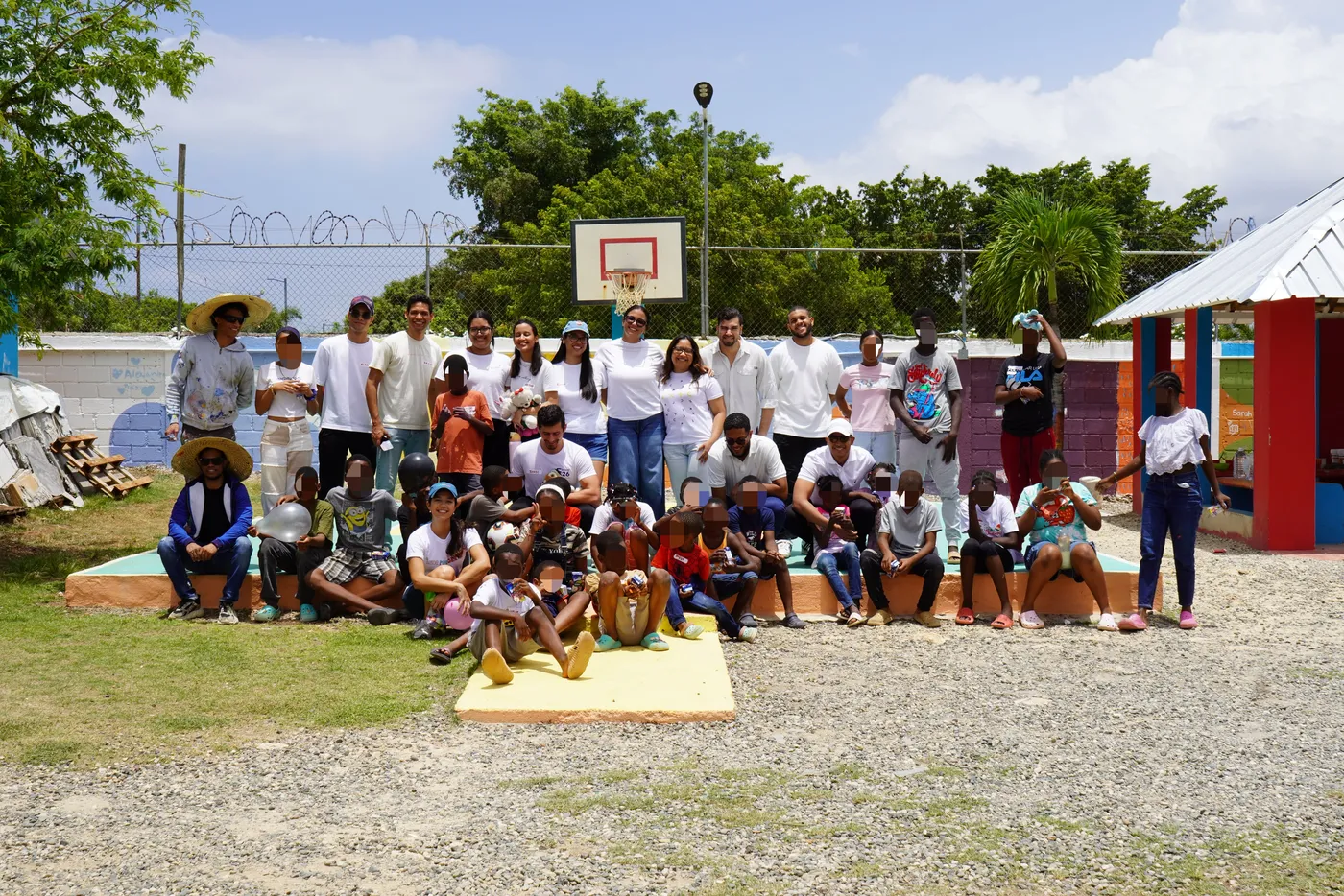 Vista amplia del hogar con la comunidad reunida en la cancha remozada